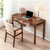 Walnut desk styled with a laptop, with drawers open showing interior storage