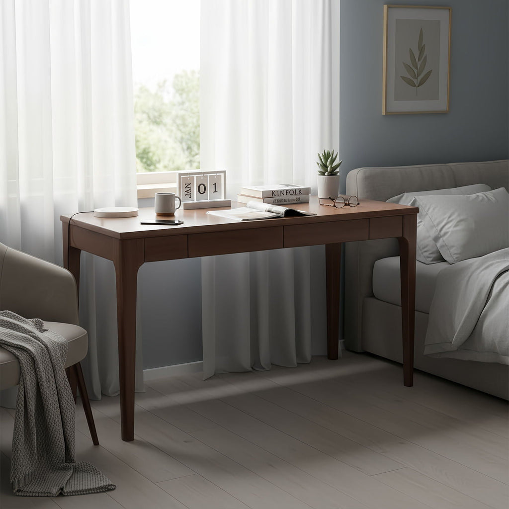 Walnut desk used as a bedside work surface in a bedroom setting