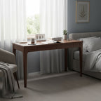 Walnut desk used as a bedside work surface in a bedroom setting