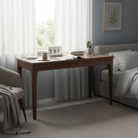 Walnut desk used as a bedside work surface in a bedroom setting